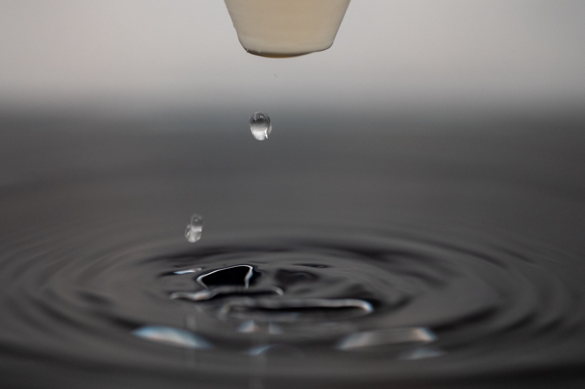 A single water drop breaking the surface of still water